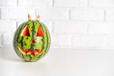 Watermelon with a smiling face like a pumpkin for Halloween
