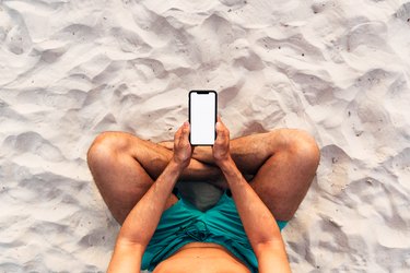 Man using smartphone at the beach