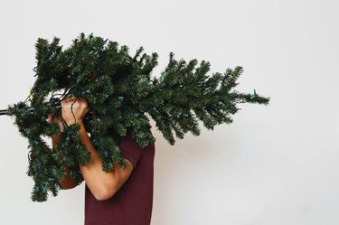 Man carrying artificial Christmas tree