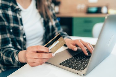 Woman online shopping on laptop with credit card