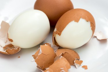 boiled eggs on plate with broken eggshell