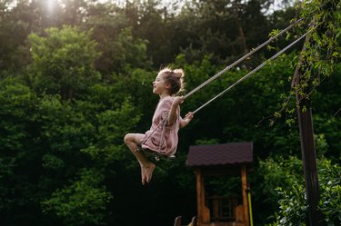 Girl swinging on garden swing.