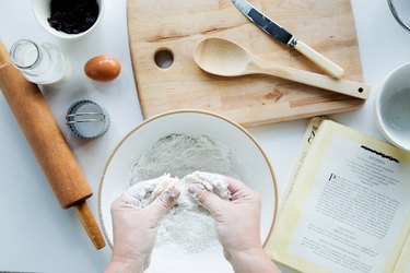 Overhead view of person blending butter with flour, making scones