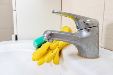 Sponge and gloves for washing dirty faucet with limescale