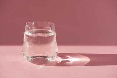 Glass of fresh pure water. Hard light, deep shadow