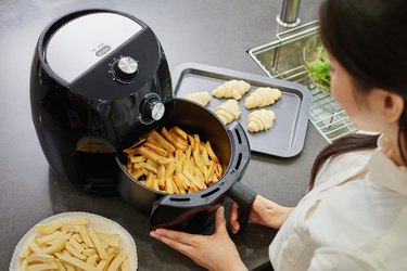 Woman taking fries out of air fryer