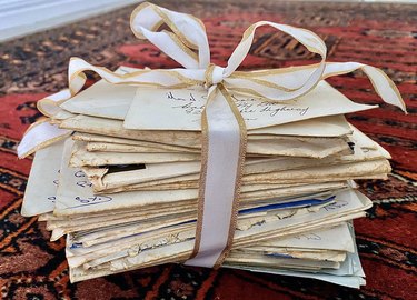 Stack of handwritten vintage love letters tied with ribbon