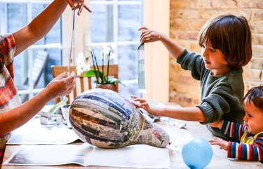 Child and mother playing with papier mache