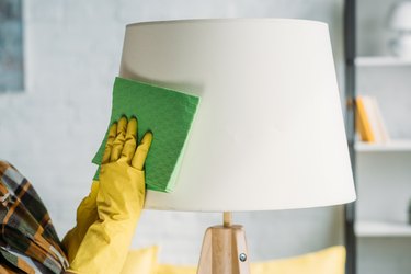 Woman dusting lamp