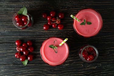 Cherry smoothie and ingredients on rustic wooden table