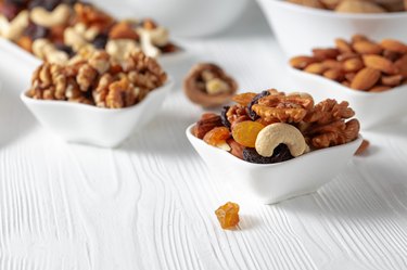 Mix of nuts and raisins on a white wooden table