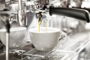 An espresso machine pouring a shot into a demitasse cup