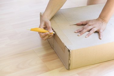 Opening Cardboard Box On Floor