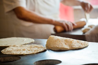 Mexican Chef Rolling, Frying Flour Tortillas in Restaurant Commercial Kitchen