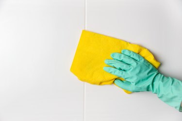 gloved hand washes ceramic tiles