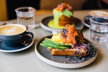 Avocado toast with salmon and poached egg served for breakfast at a cafe