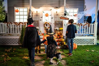 Young kids trick or treating at night during Halloween