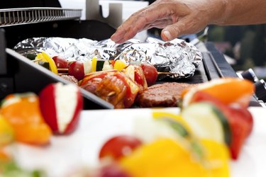 Vegetarian skewers and meat on barbecue grill