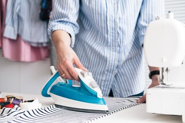 Midsection Of Craftswoman Ironing Textile At Workshop