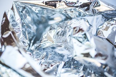 Abstract Silver Background Wrinkled, Wrinkles, Shiny Background Of Plastic Waste With Texture