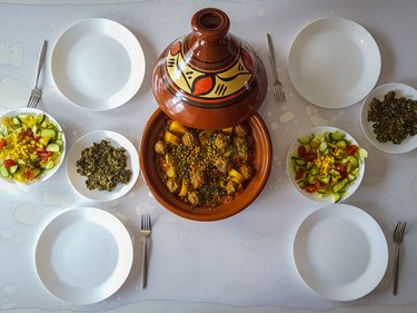 High angle view of food served on table (tagine of peas and potatoes with meatballs, salad and spinach)