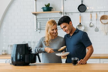 Couple preparing meal in air fryer