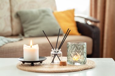 Scented candles and aroma incense sticks on table in living room