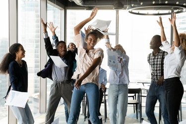 Overjoyed young african american colleagues dancing in modern office.