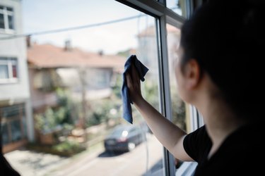 Yong woman cleaning window