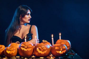 Beautiful witch with Halloween pumpkins