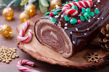 Traditional chocolate trunk cake or log cake on table with Christmas decorations