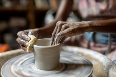 Female potter creating a bowl in her art studio