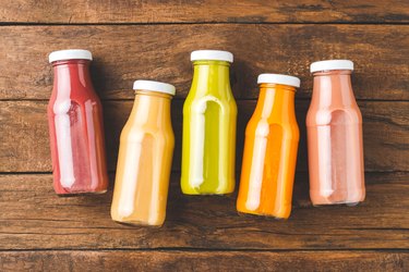 Fresh fruit and vegetable smoothies in bottles on vintage wooden table