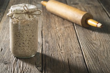 Sourdough starter for bread and bakery leavening agent levain on rustic wooden table