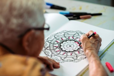 Senior women coloring with marker at her house