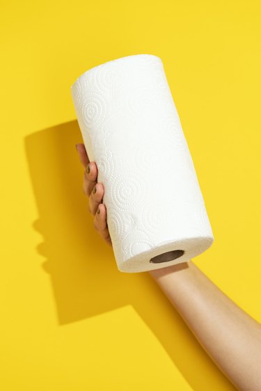 Hand holding paper towel roll