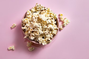Popcorn in a pink bowl over pink background