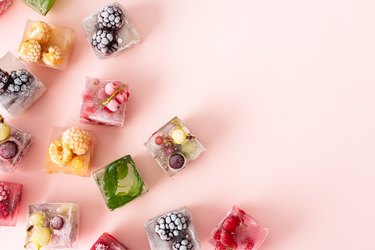 Ice cubes with various berries frozen inside