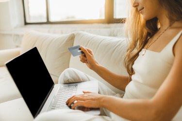 Young Woman relaxing on sofa and Shopping Online With  Credit Card and Laptop