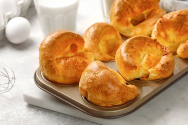 Yorkshire pudding in baking dish, in muffin cups. Homemade traditional English food. Grey background. Close up