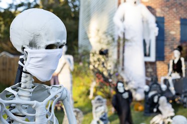 Skeleton decoration wears protective facial mask during Covid-19 pandemic in Halloween yard decorations