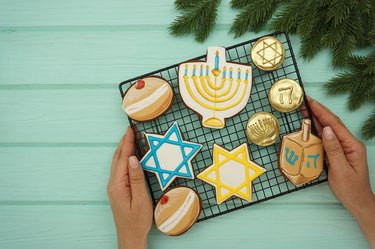 Women's hands hold a lattice with gingerbread symbols of Hanukkah