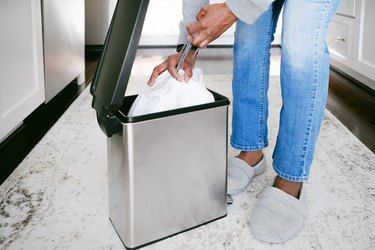 Woman Removes Trash Bag From Can