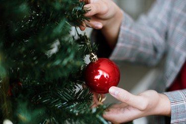 Close-up of a woman decorating a Christmas tree