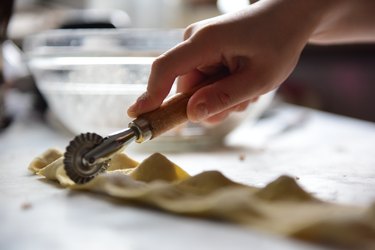Separating pasta parcels using a pasta cutter wheel to make tortellini