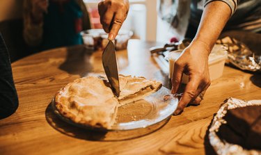 Woman cuts a slice of Warm Apple Pie