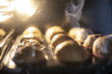 Woman preparing muffins and putting it into oven