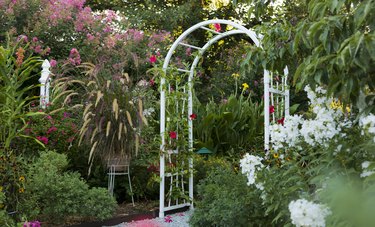 Arbor surrounded by lush summer gardens