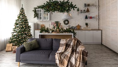 Modern kitchen interior with Christmas tree and sofa.