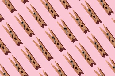 Rows of old clothespins repeated on pink background